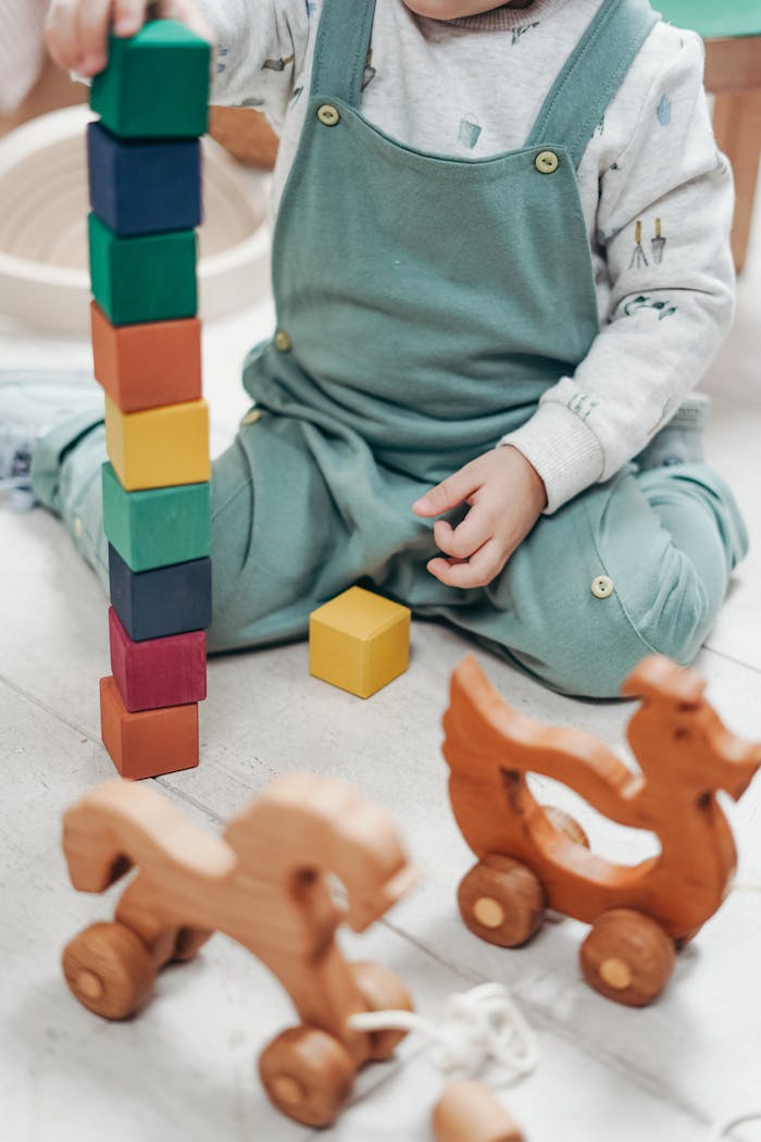 Projekte und Ziele A child enjoying playtime indoors with colorful wooden blocks and toys.