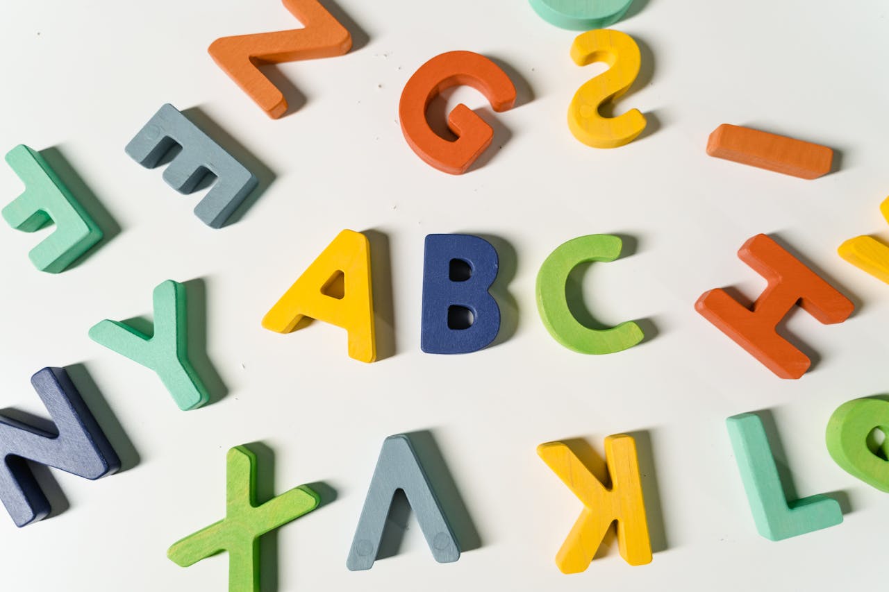 Bright, colorful wooden alphabet letters scattered on a surface ideal for children